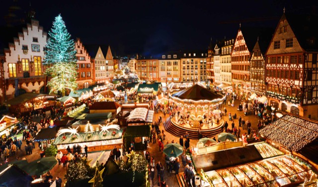 Weihnachtsmarkt mit beleuchteten Staenden und Besuchern